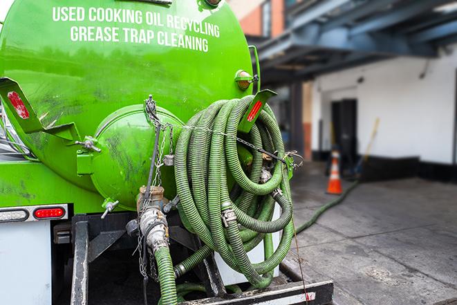 a large grease trap being pumped by a specialist in Glendale